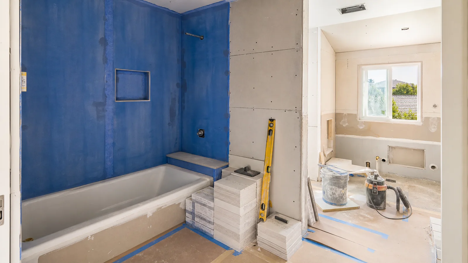 Kimmel Elite Construction bathroom remodel hero with waterproofed shower walls, tile staging, protected floors, and ventilation prep