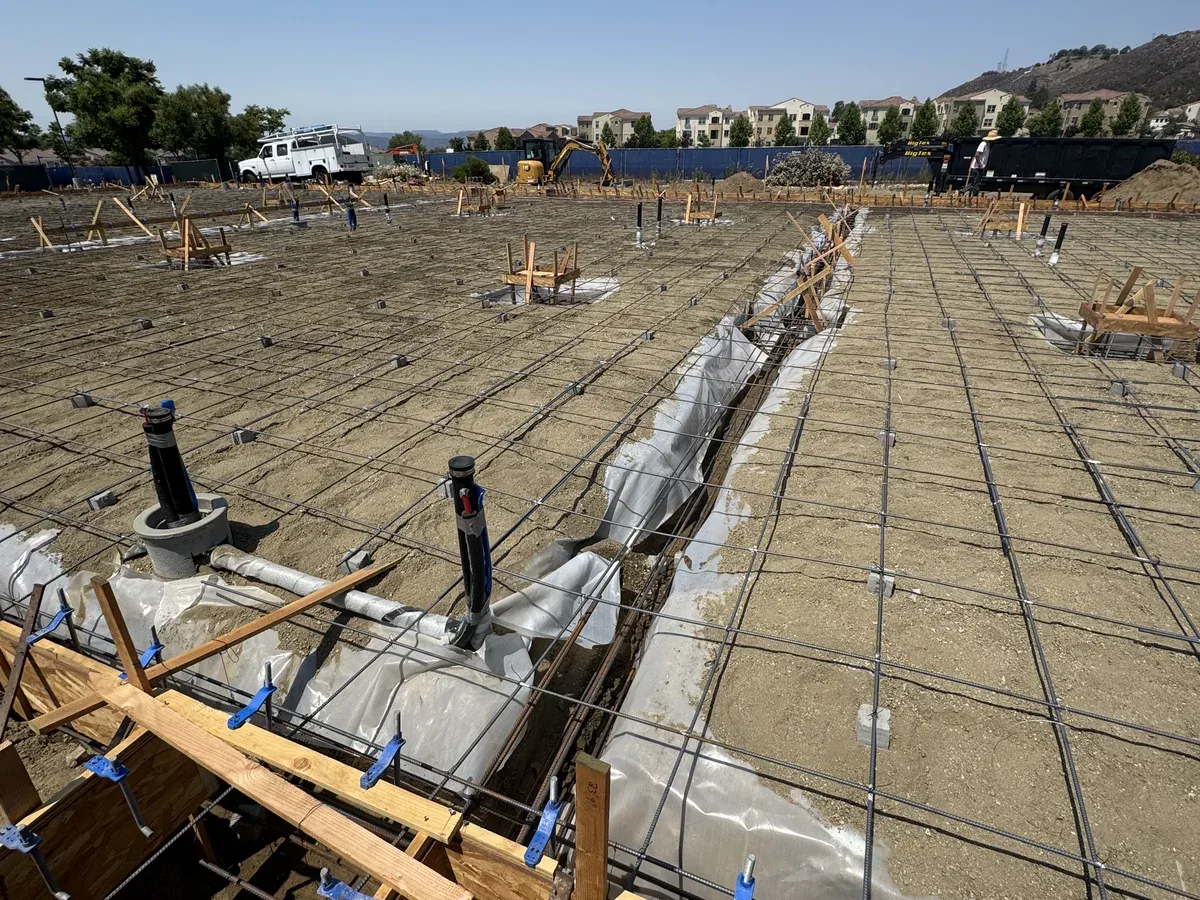 Kimmel Elite Construction concrete foundation work with rebar, plumbing rough-ins, forms, and structural prep before inspection